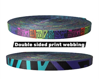 May include: Two rolls of double-sided print webbing. The top roll features a vibrant pattern with purple, pink, orange, green, and black geometric shapes. The bottom roll displays a teal, black, and purple design. The text "Double sided print webbing" is displayed in a black rectangle.