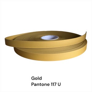 Puede incluir: Un rollo de moldura autoadhesiva dorada. La moldura es de color Pantone 117 U y est&aacute; enrollada, con el extremo de la moldura extendi&eacute;ndose. La moldura se utiliza probablemente para bordes o fines decorativos.