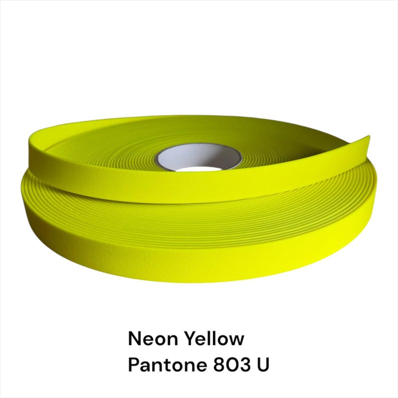 Puede incluir: Un rollo de cinta amarilla ne&oacute;n, Pantone 803 U, se muestra sobre un fondo blanco. La cinta est&aacute; enrollada, revelando un n&uacute;cleo de cart&oacute;n blanco. El color amarillo brillante es prominente, y el texto "Neon Yellow" y "Pantone 803 U" es visible.