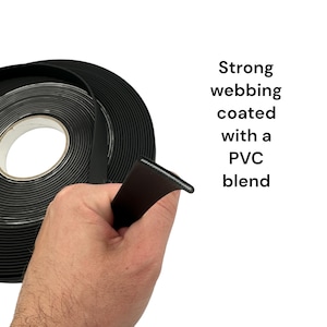 Puede incluir: Cinta negra recubierta con una mezcla de PVC, mostrada en rollo y sostenida en la mano. El texto a la derecha dice: "Strong webbing coated with a PVC blend."