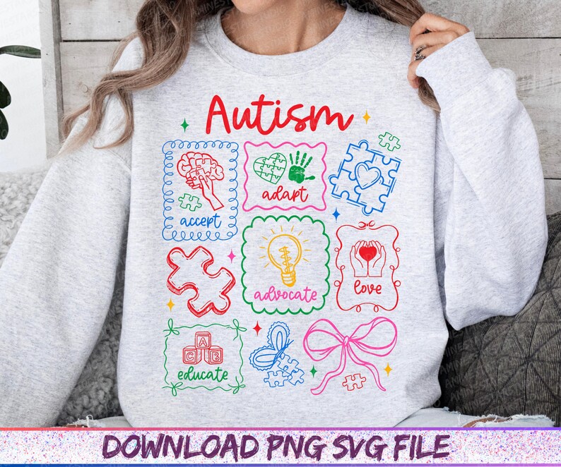 May include: A light gray sweatshirt with the word "Autism" in red script. The sweatshirt features colorful framed illustrations with words like "accept," "adapt," and "love." The bottom of the image has the text "DOWNLOAD PNG SVG FILE."