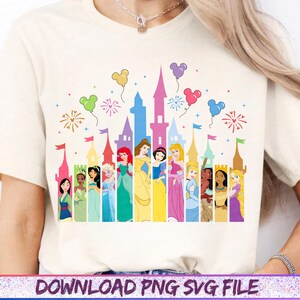May include: Cream-colored t-shirt featuring a colorful graphic of a castle silhouette with Disney princesses. The design includes balloons, fireworks, and the text "DOWNLOAD PNG SVG FILE" at the bottom.