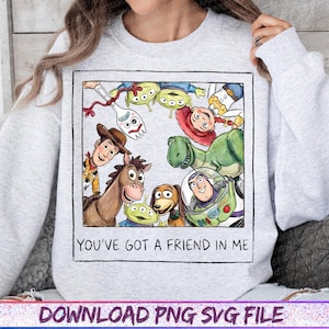Peut inclure: Un sweat-shirt gris clair &agrave; col rond avec une impression graphique carr&eacute;e repr&eacute;sentant des personnages de Toy Story, dont Woody, Buzz l'&Eacute;clair, Jessie, Rex, Bayonne, Fourchette et des extraterrestres. Le texte "YOU'VE GOT A FRIEND IN ME" est imprim&eacute; en dessous.