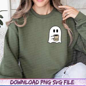 May include: An olive green sweatshirt featuring a white ghost graphic holding a coffee cup. The coffee cup has the word "COFFEE" printed on it. The sweatshirt is a long-sleeved crew neck.
