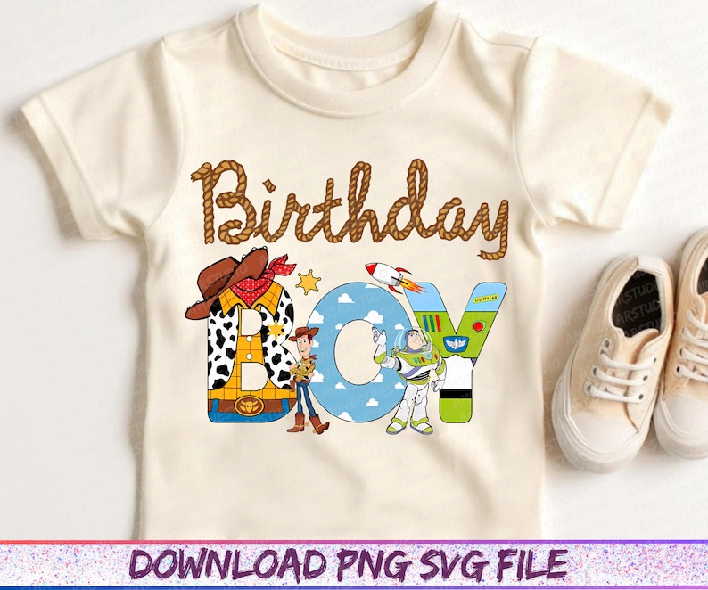 May include: Cream-colored short-sleeved t-shirt with the words "Birthday Boy" in brown rope-style lettering. The word "BOY" features cartoon characters and a rocket ship. A pair of beige sneakers are on the right.