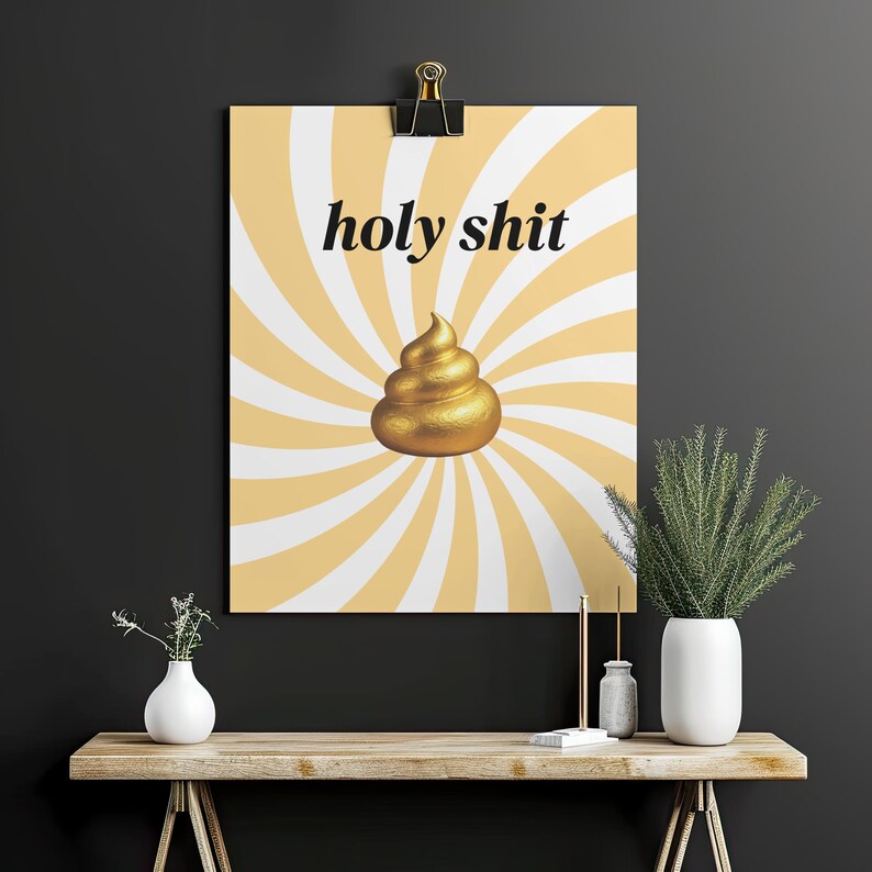 K&ouml;nnte beinhalten: Ein Poster mit dem Schriftzug "holy shit" in schwarzer Schrift &uuml;ber einem goldenen Kackhaufen-Emoji. Der Hintergrund hat ein gelb-wei&szlig;es Spiralmuster. Das Poster ist an einer schwarzen Wand befestigt.