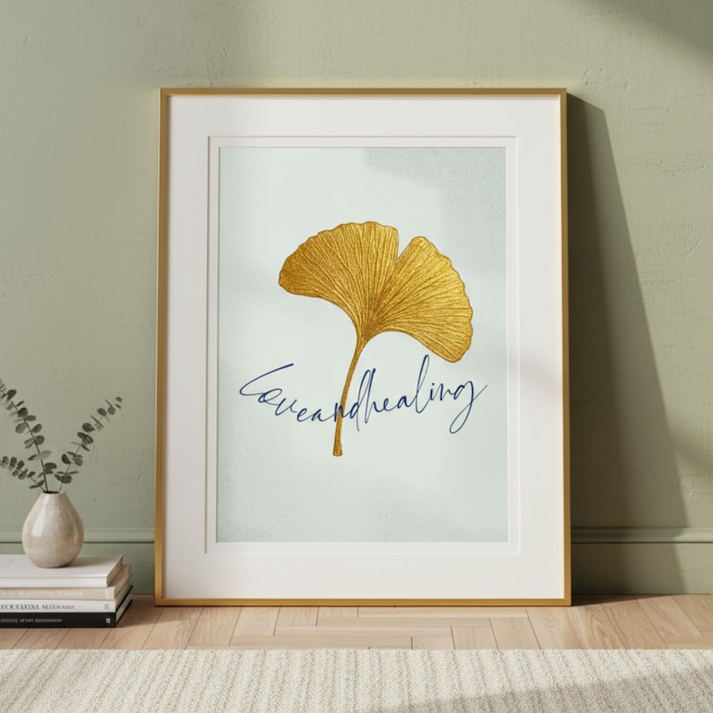 Pu&ograve; includere: Stampa artistica incorniciata con un design a foglia di ginkgo dorata e la scritta corsiva "love and healing". L'opera &egrave; ambientata su uno sfondo azzurro chiaro, racchiusa in una cornice dorata.