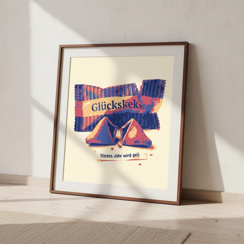 May include: A framed print featuring a stylized illustration of a fortune cookie package and two opened cookies. The package is blue and red with the German word "Gl&uuml;ckskeks". The text "Dieses Jahr wird geil" is also present.