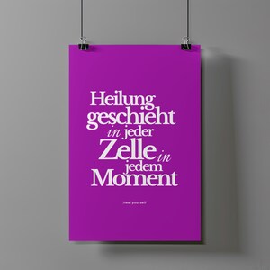 May include: A purple poster with the German text "Heilung geschieht in jeder Zelle in jedem Moment" in white, with "heal yourself" at the bottom. The poster is held by two black binder clips.