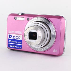 May include: A pink Samsung digital camera with a silver lens and flash. The camera has a 12.2-megapixel resolution, 27mm wide-angle lens, and 15 auto settings. The camera has a 5x zoom.