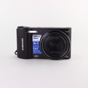 Puede incluir: C&aacute;mara digital Samsung negra con zoom 18x y conectividad Wi-Fi. La c&aacute;mara cuenta con una lente Schneider y un modo manual completo. La c&aacute;mara tiene una lente gran angular de 24 mm.