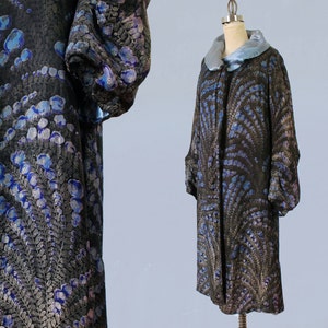 May include: A long black coat with a blue and silver floral pattern. The coat has a blue satin collar and long sleeves.
