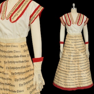 Peut inclure: Une robe blanche avec des bordures rouges et blanches, réalisée à partir de pages de journaux réutilisées. La robe est imprimée avec les mots "The Bethlehem Globe Times" répétés sur toute sa surface. La robe est portée par un mannequin.