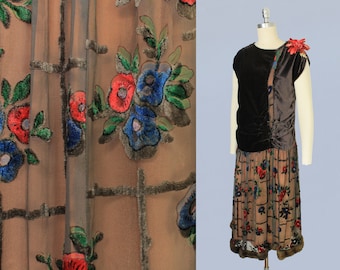 May include: A vintage 1920s dress with a brown velvet bodice and a sheer chiffon skirt with a floral pattern. The skirt has a brown velvet trim and a fur hem.