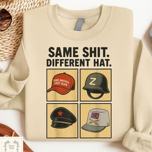 Könnte beinhalten: Beiges Sweatshirt mit dem Text "SAME SHIT. DIFFERENT HAT." und vier Bildern von Hüten: eine rote Baseballkappe, ein grüner Militärhelm, eine schwarze Kappe mit rotem Stern und ein grauer Hut mit einer Flagge.