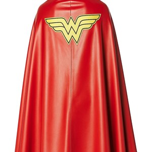 May include: A red cape with a yellow and black emblem on the back. The cape is made of a shiny material and is designed to be worn. The emblem is a stylized "W" with wings, a superhero-themed costume accessory.