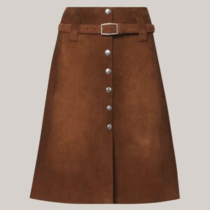 May include: A brown suede skirt with a button-down front and a matching belt. The skirt has a classic A-line shape and features silver-colored buttons and a buckle. The belt is secured with a silver-colored buckle.