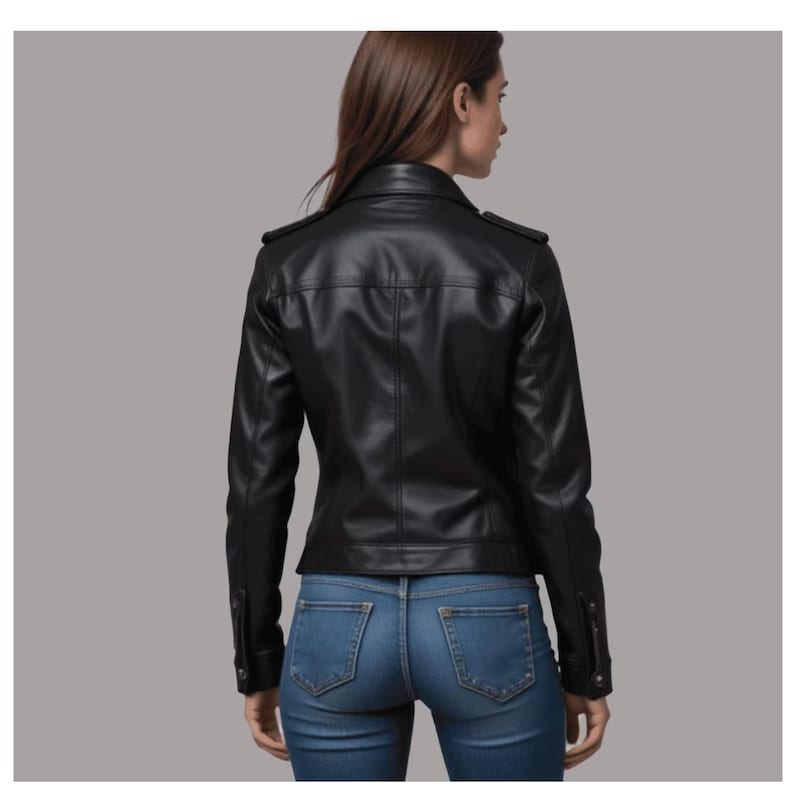 May include: A black leather jacket with a classic design, featuring a notched collar, shoulder epaulets, and buttoned cuffs. The jacket is paired with blue denim jeans. The model is viewed from the back.