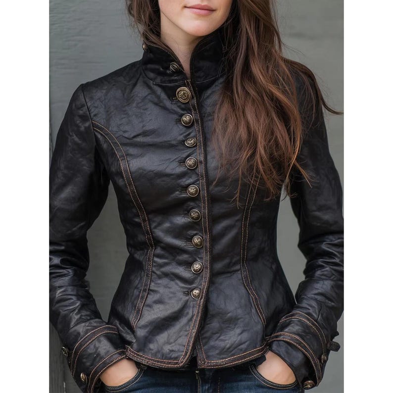 May include: Black leather jacket with a high collar and multiple gold-colored buttons down the front. The jacket has brown stitching and detailing on the cuffs and seams. The sleeves are long, and the jacket appears to be fitted.