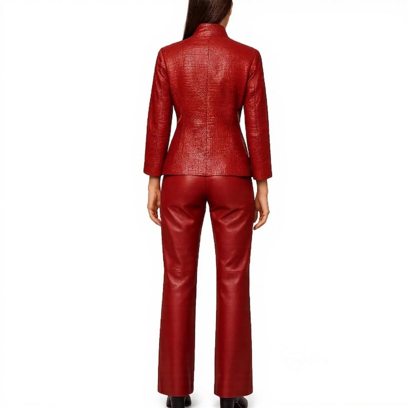 Pode incluir: Um fato de couro vermelho, composto por um casaco texturizado com gola mandarim e cal&ccedil;as flare a condizer. O casaco tem mangas compridas e um corte sob medida. As cal&ccedil;as s&atilde;o de estilo cl&aacute;ssico de perna reta. O fato &eacute; um conjunto arrojado e monocrom&aacute;tico.