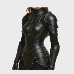 May include: Black leather armour featuring a high collar, shoulder pauldrons, and articulated plates. The armour is detailed with small, gold-coloured rivets. The design suggests a medieval or fantasy theme.