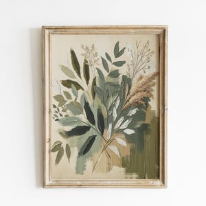Könnte beinhalten: Ein gerahmter botanischer Druck mit einem Bouquet aus Blättern und Gräsern in Grün-, Weiß- und Beigetönen. Das Kunstwerk hat ein strukturiertes, gemaltes Aussehen und ist vor einem neutralen Hintergrund platziert. Der Rahmen ist aus hellem, verwittertem Holz.