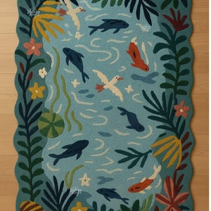 May include: A rectangular rug with a scalloped edge, depicting a pond scene. The rug has a light blue background with dark blue fish, white birds, and orange fish. Green and yellow plants and flowers surround the pond.