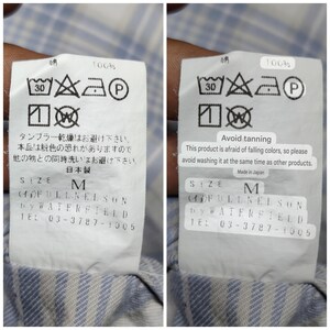 May include: Close-up of a white clothing tag with black text and symbols. The tag includes washing instructions, size M, and the brand "(AOFULLNELSON by WATERFIELD". The tag also has a warning about color bleeding.