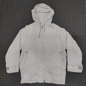 Puede incluir: Chaqueta con capucha de color beige claro con cremallera completa, dos bolsillos delanteros y puños ajustables. La chaqueta tiene una capucha con cordón y un diseño sencillo, ideal para uso diario.