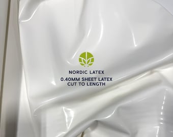 May include: White sheet latex material with the text "NORDIC LATEX 0.40MM SHEET LATEX CUT TO LENGTH" and a green logo. The latex has a glossy finish and is folded, creating shadows and highlights.