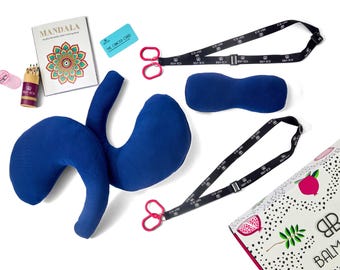 Könnte beinhalten: Eine Sammlung von Artikeln, bestehend aus einem blauen Nackenkissen, einer blauen Schlafmaske, zwei schwarzen Schlüsselbändern mit rosa Ringen, einem Mandala-Malbuch, Stiften mit Anspitzer, einer kleinen blauen Karte und einer weißen Box.