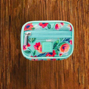 Blue Floral travel pill organizer case closed, compact zippered medication pouch for daily use, portable storage for vitamins and prescriptions.