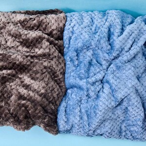 Soft plush fuzzy blankets in Dove Grey, Campfire, Ash Blue, and Lilac folded side by side, Balm Box cozy throw