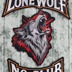 May include: A three-piece embroidered patch set featuring a central howling wolf head in gray, black, and red. The top arched patch reads LONE WOLF in white letters, and the bottom arched patch reads NO CLUB in white letters.