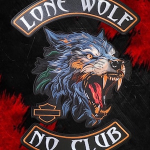 Puede incluir: Un conjunto de parches bordados negros con una cabeza de lobo gruñendo con detalles de pelaje azul, naranja y verde. El arco superior dice LONE WOLF y el arco inferior dice NO CLUB en letras blancas con bordes naranjas y un escudo.