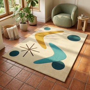 May include: A rectangular area rug featuring a cream-coloured background with a mid-century inspired pattern of teal and mustard yellow boomerang shapes, dark teal circles, and a brown starburst design spread across the surface of the rug.