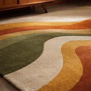 May include: A colorful area rug with a retro design. The rug features wavy stripes in shades of orange, yellow, green, and cream. The rug is made of a soft, textured material and is suitable for a living room or bedroom.