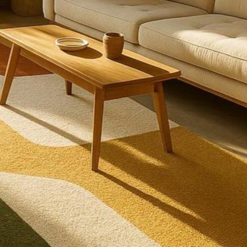 May include: A wooden coffee table with a rectangular top and angled legs. A small ceramic dish and a brown vase sit on the table. The table is placed on a rug with a yellow, white, and green wavy pattern.