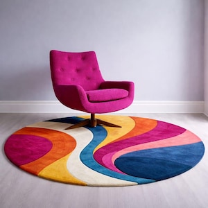 May include: A vibrant, round area rug with a retro design featuring wavy stripes in shades of blue, pink, orange, yellow, and white. A magenta swivel chair with a wooden base sits above the rug, creating a colorful and stylish interior design.