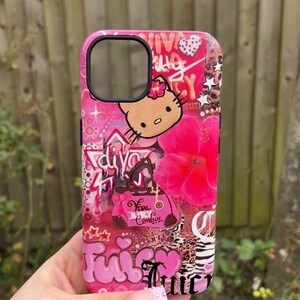 May include: Pink phone case with a collage design featuring a Hello Kitty graphic, a pink flower, and the words "Juicy Couture". The case has a glossy finish and a black camera cutout.