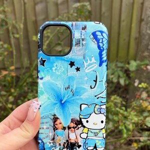K&ouml;nnte beinhalten: Eine blaue Handyh&uuml;lle mit floralem Design, Sternen und einem Schmetterling. Die H&uuml;lle enth&auml;lt auch Illustrationen von Bratz-Puppen und Hello Kitty. Die H&uuml;lle hat einen schwarzen Rand.