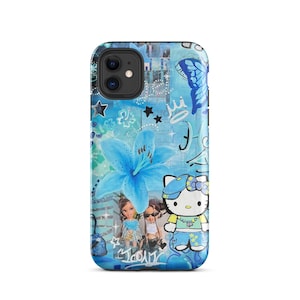May include: A blue phone case with a collage design. It features a large blue flower, a butterfly, stars, a crown, and a Hello Kitty character. The case also includes images of dolls and other graphics.