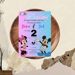 Puede incluir: Una colorida tarjeta de invitaci&oacute;n con un fondo degradado rosa y azul, con Minnie y Mickey Mouse. La tarjeta anuncia el segundo cumplea&ntilde;os de Emma y Jack, con el texto "Oh Twodles!" y los detalles del evento.