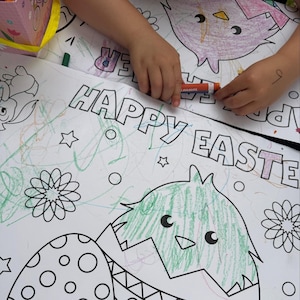 K&ouml;nnte beinhalten: Ein gro&szlig;es wei&szlig;es Malblatt mit den Worten "HAPPY EASTER" in gro&szlig;en Buchstaben. Das Blatt zeigt Illustrationen zum Thema Ostern, darunter ein Ei, aus dem ein K&uuml;ken schl&uuml;pft, Blumen und Sterne. Das Blatt ist teilweise mit gr&uuml;nen und orangen Markern ausgemalt.