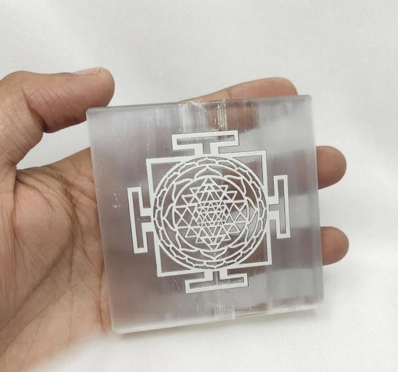 Shri Yantra crystal grid plate made from translucent white selenite with polished edges and detailed laser engraving.