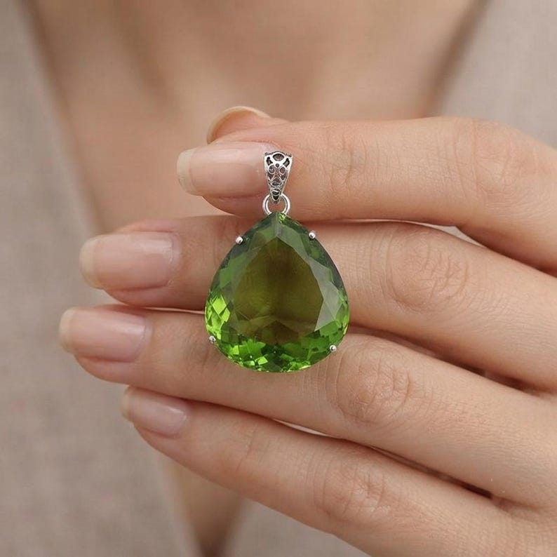 Green emerald pendant necklace on white background, sterling silver rhodium finish, heart chakra meditation jewelry