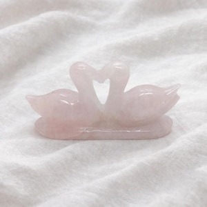 Hand-carved natural pink rose quartz love birds figurine highlighting the dual swan sculpture forming a heart shape, ideal for romantic home decor.