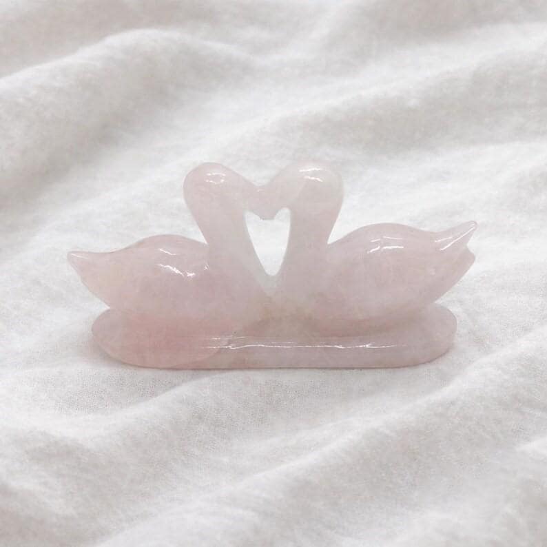 Hand-carved natural pink rose quartz love birds figurine highlighting the dual swan sculpture forming a heart shape, ideal for romantic home decor.