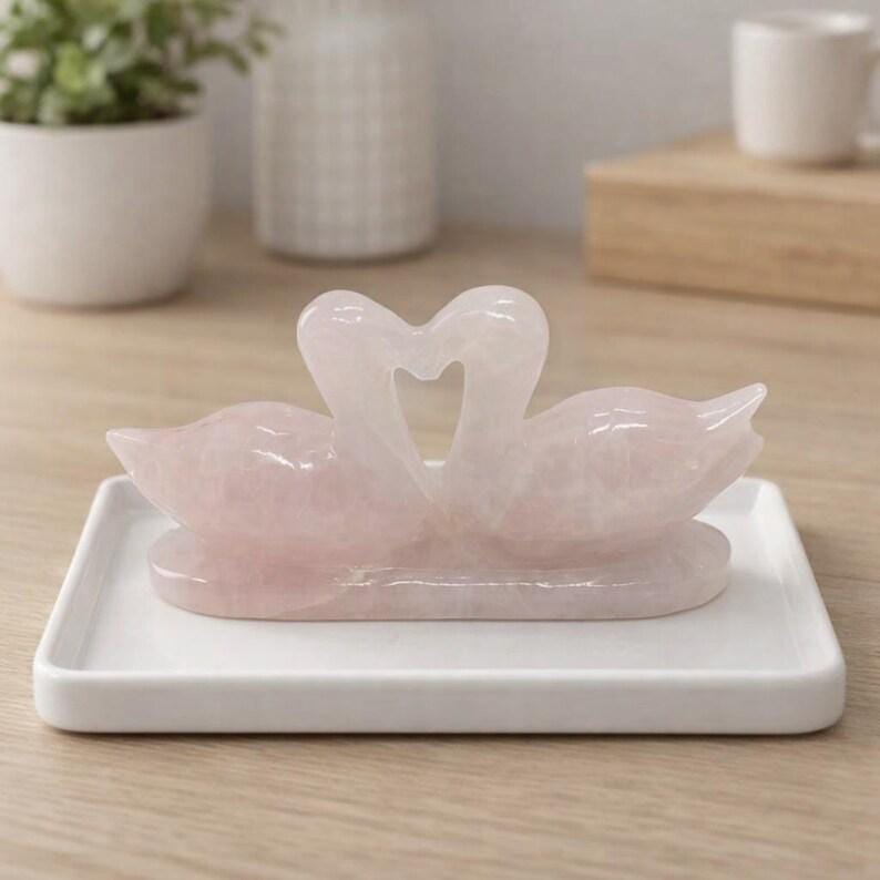 Side profile of the rose quartz love birds gemstone carving demonstrating its compact size and stable flat base for desktop display.