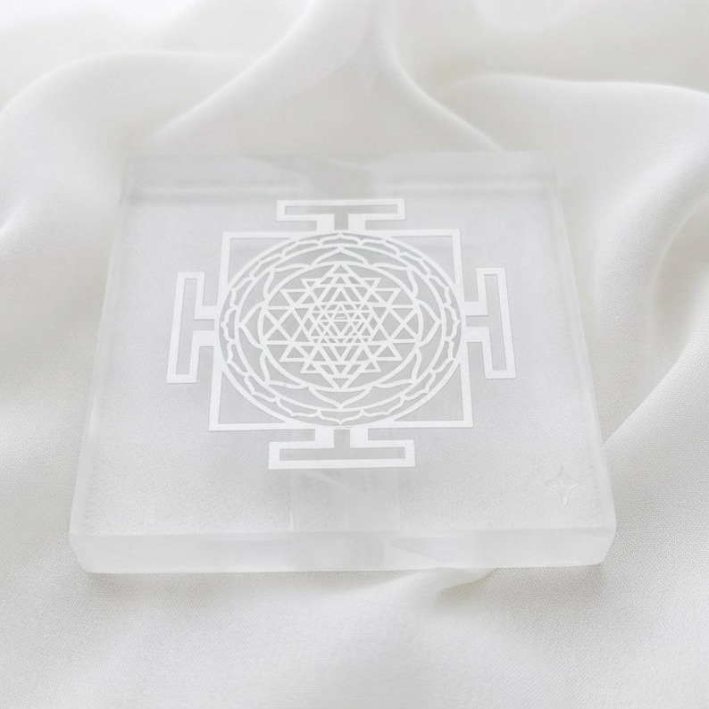 Square white selenite charging plate engraved with a detailed Shri Yantra sacred geometry design for crystal grid and altar decor.